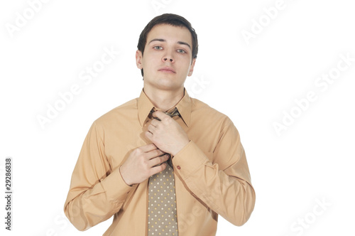 Young businessman corrects tie