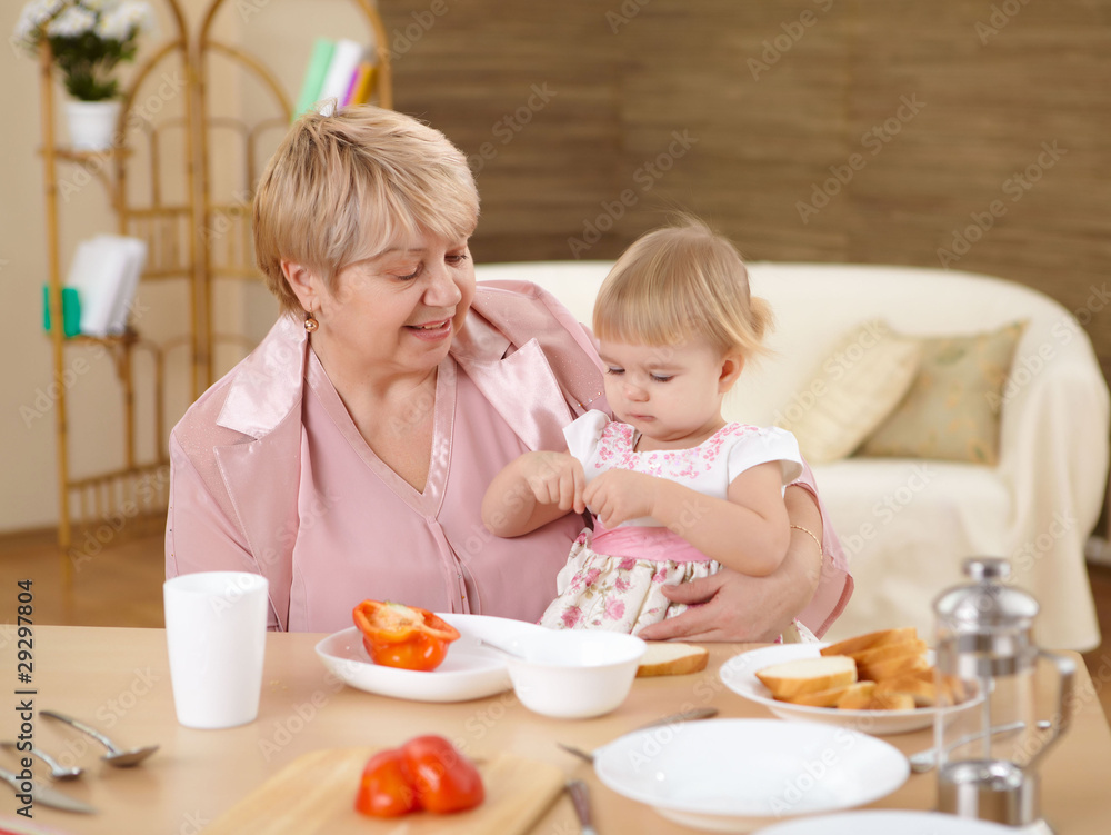 grandmother feeding granddaughter at home grandmother feeding granddaughter at home