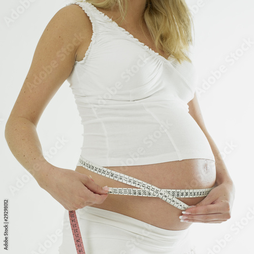 pregnant woman with tape measure photo