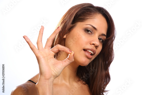 Beautiful young woman gives ok sign to camera