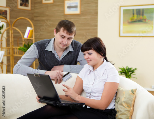 couple with a laptop at home © Sergey Nivens