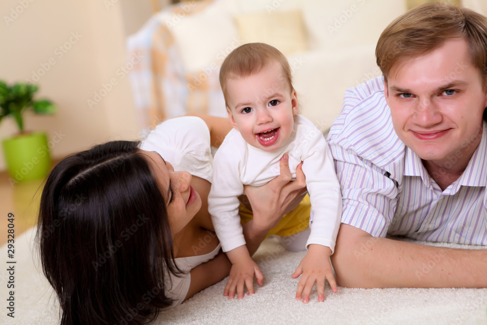 young family at home playing with a baby