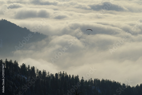 Gleitschirmflieger vor Nebelwand photo