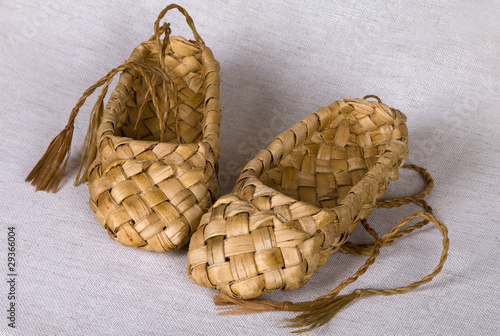 Pair  bast shoes birch bark on a linen fabric photo