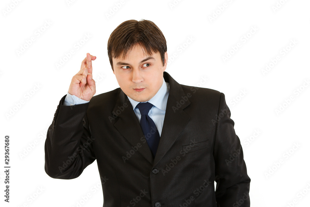 Superstitious young businessman holding crossed fingers Superstitious young businessman holding crossed fingers