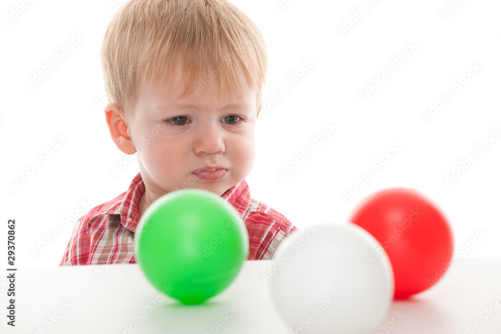 Confused kid looking at balls Confused kid looking at balls