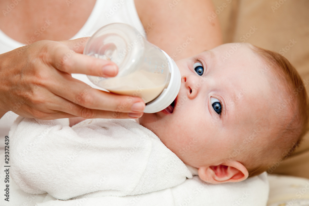 Mother feeding newborn son with feeding bottle Mother feeding newborn son with feeding bottle
