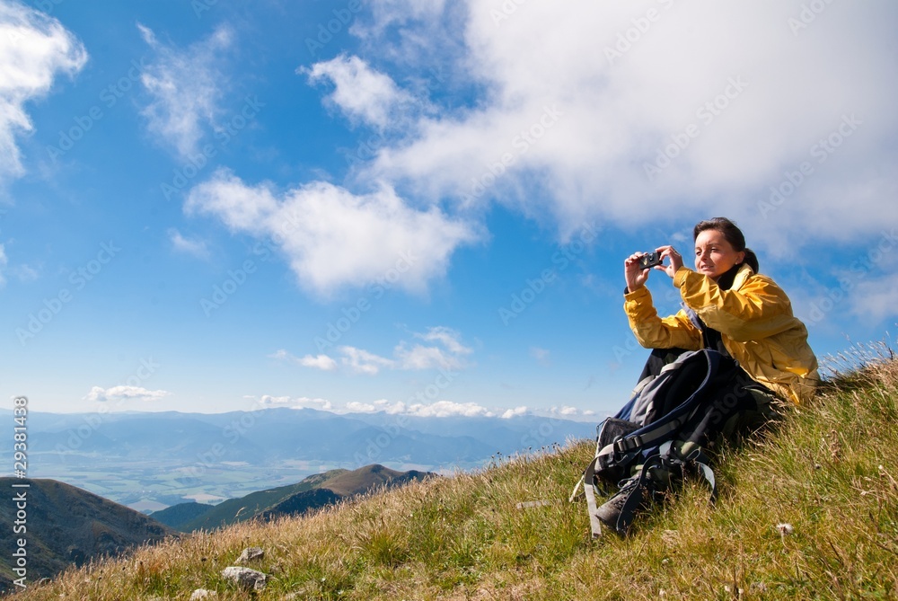 Young woman in mountains - taking picture