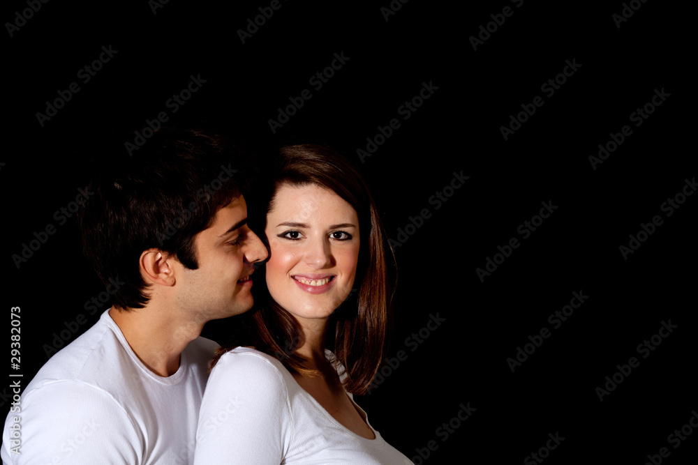 Loving couple on dark background: boy giving a kiss Loving couple on dark background: boy giving a kiss