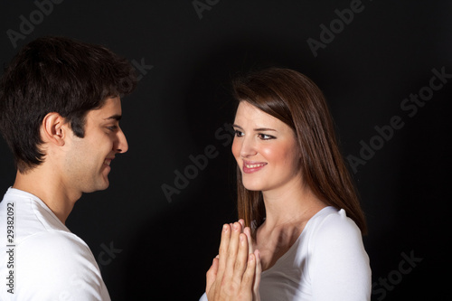 Smiling loving couple touching hands on black backgroundhan