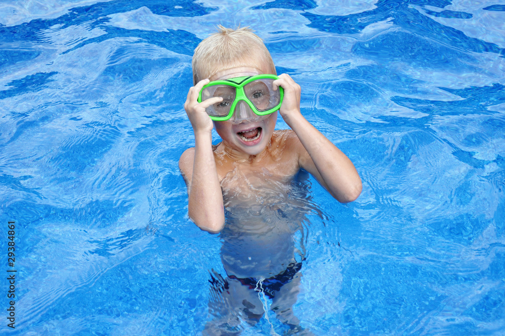 Little blondy boy having fun in the swimming pool