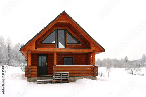 wooden cottage in a snowy place