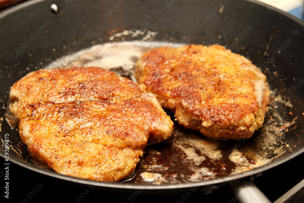 Paniertes Schnitzel in der Pfanne Paniertes Schnitzel in der Pfanne