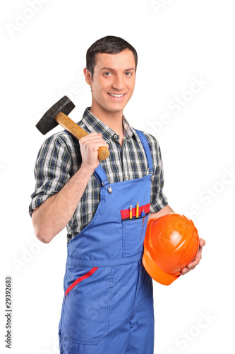 Male worker wearing blue overall with a hammer and helmet