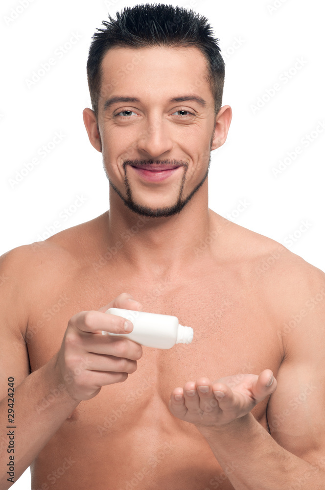 Young man applying cream. Cosmetic
