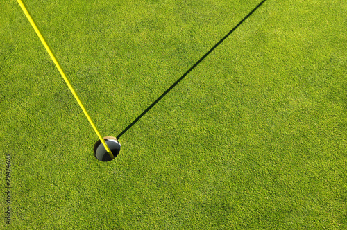 Golf hole in a green grass field background