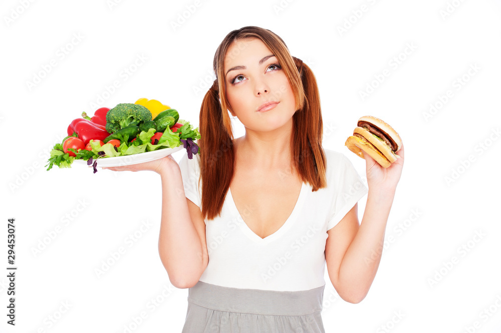 woman holding fresh vegetable and burger