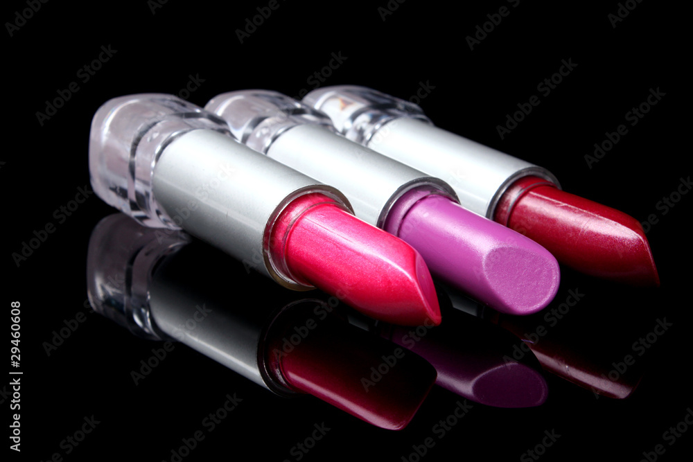 three bright lipsticks on a black background three bright lipsticks on a black background