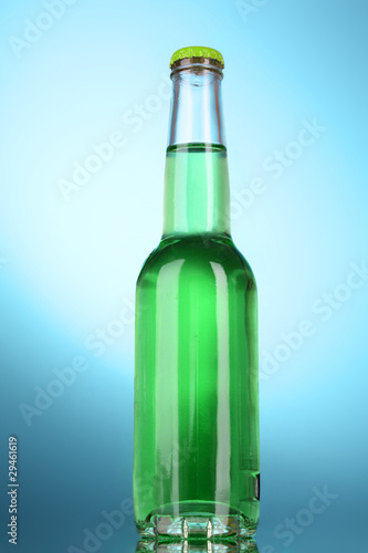 Bottle with alcohol on blue background
