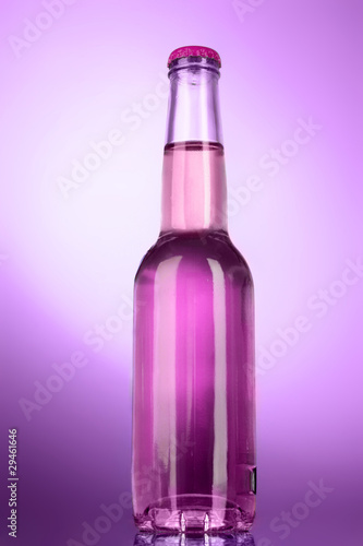 Bottle with alcohol on purple background