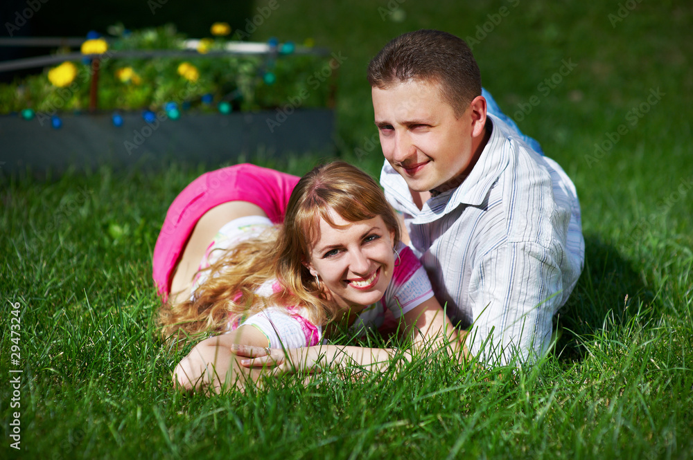 Fototapeta premium Happy young woman and man on green grass