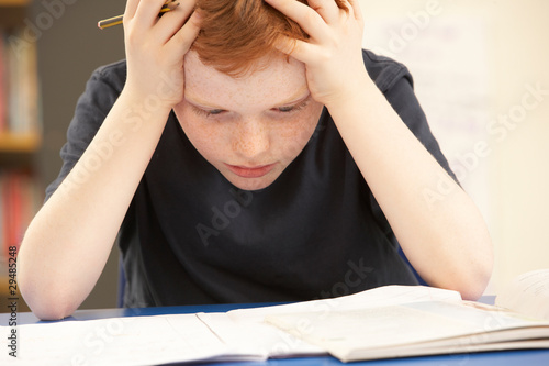 Φωτογραφία Stressed Schoolboy Studying In Classroom
