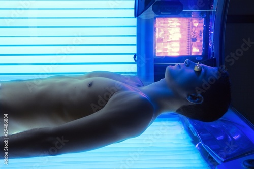 Tanning solarium young man laying