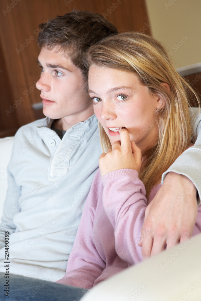 Nervous Looking Teenage Girl Sitting On Sofa At Home With Boyfri Nervous Looking Teenage Girl Sitting On Sofa At Home With Boyfri