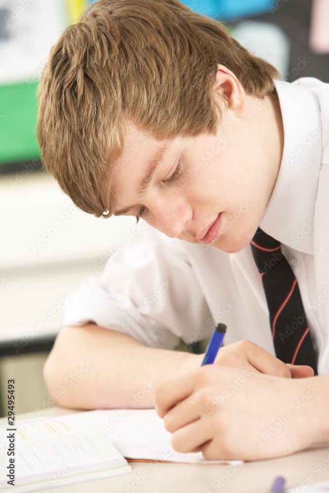 Male Teenage Student Studying In Classroom Male Teenage Student Studying In Classroom