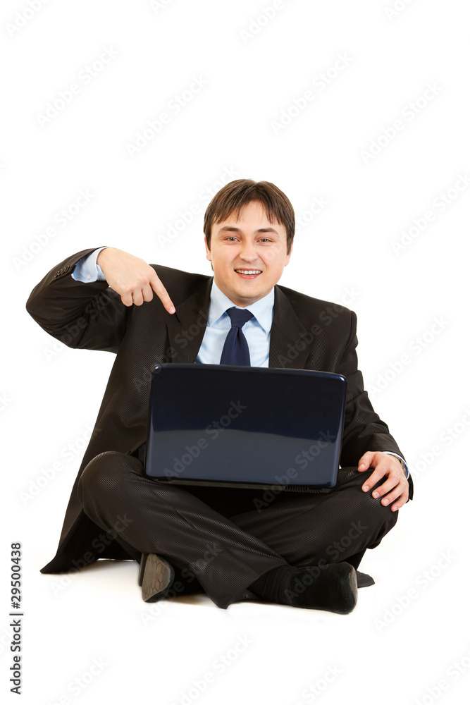 Businessman sitting on floor and pointing finger at laptop Businessman sitting on floor and pointing finger at laptop