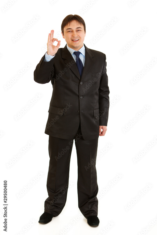 Smiling young businessman showing ok gesture isolated on white. Smiling young businessman showing ok gesture isolated on white.
