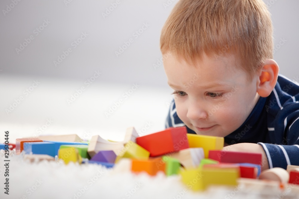 Adorable ginger-haired boy playing with cubes Adorable ginger-haired boy playing with cubes