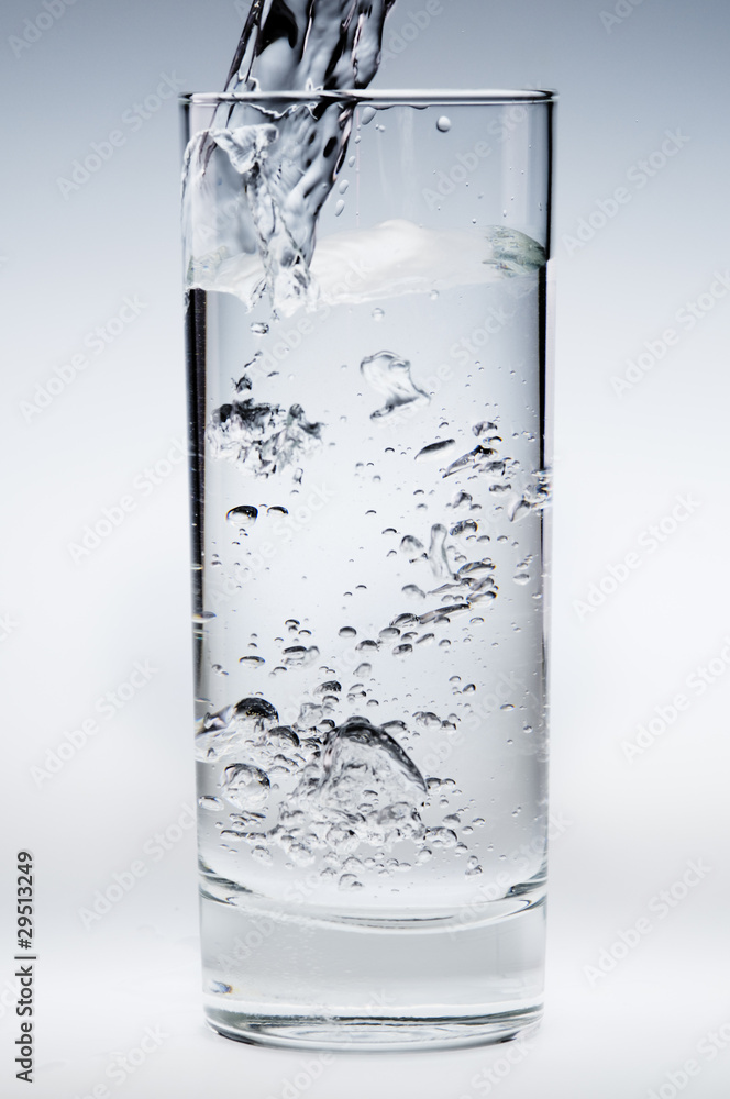 Pouring mineral water stream into a glass Pouring mineral water stream into a glass