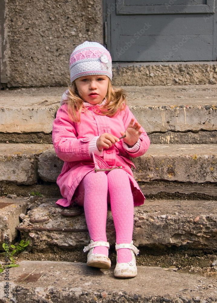 Little girl sits on a stone staircase Little girl sits on a stone staircase