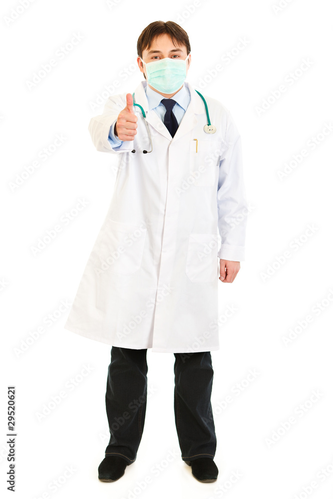 Medical doctor wearing mask and showing thumbs up gesture Medical doctor wearing mask and showing thumbs up gesture