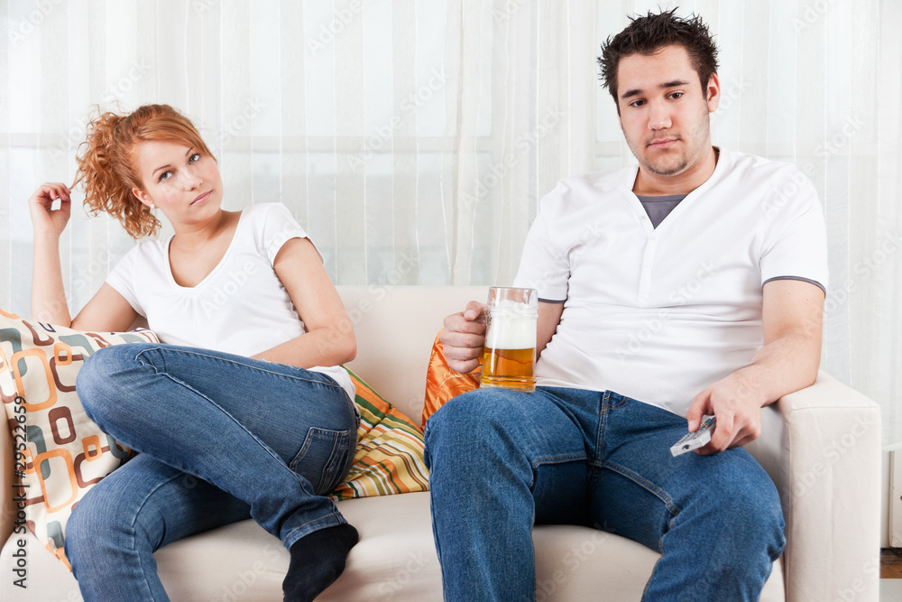 young boy watching football in the television with a beauty girl young boy watching football in the television with a beauty girl