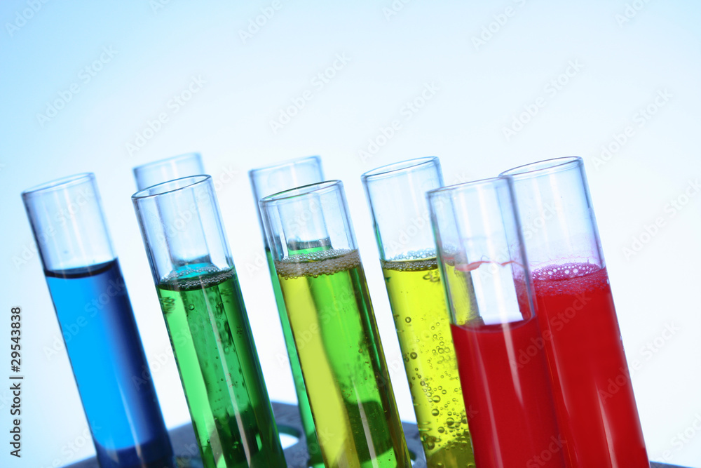 Multicoloured test tubes in the stand on blue background Multicoloured test tubes in the stand on blue background