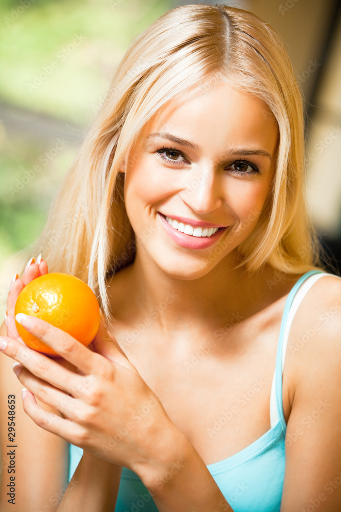 Portrait of young smiling woman with orange at home Portrait of young smiling woman with orange at home