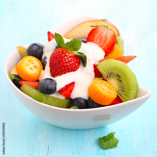 Fruity summer salad in white bowl with yogurt