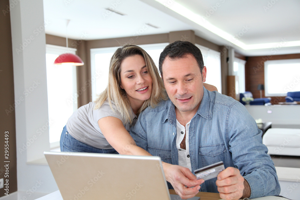 Couple doing online shopping wih laptop computer Couple doing online shopping wih laptop computer