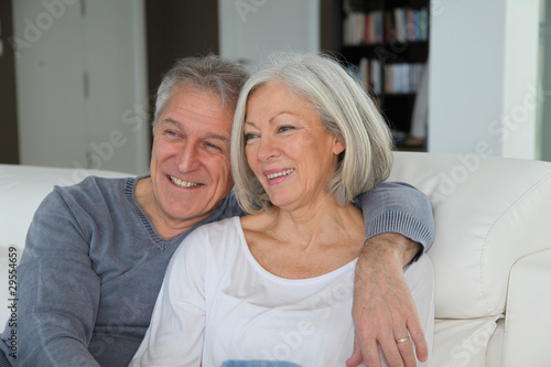 Senior couple sitting in sofa at home
