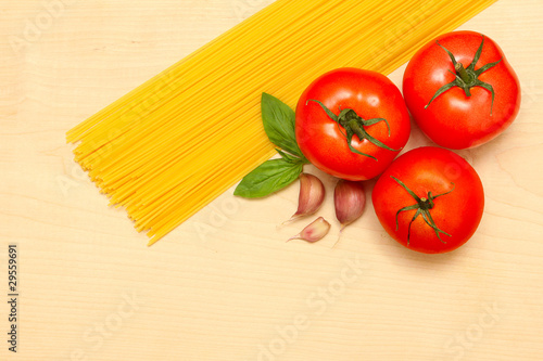 pasta, garlic, tomatoes and basil on a wooden board