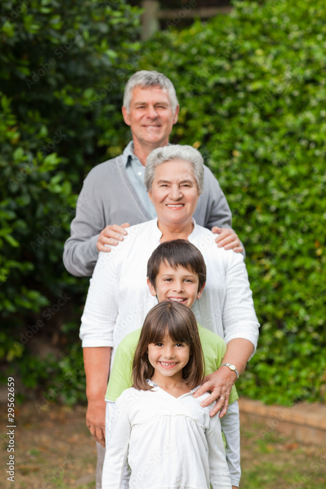Fototapeta premium Grandparents with their children looking at the camera in the ga