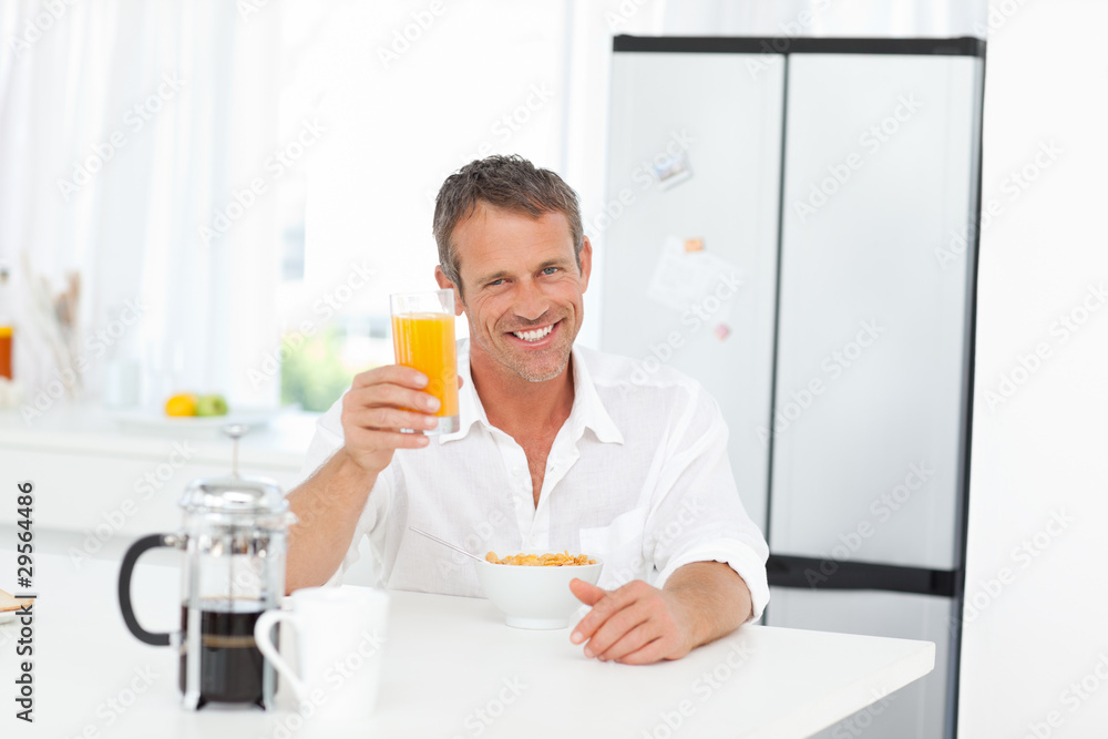 Handsome man having his breakfast in the kitchen Handsome man having his breakfast in the kitchen