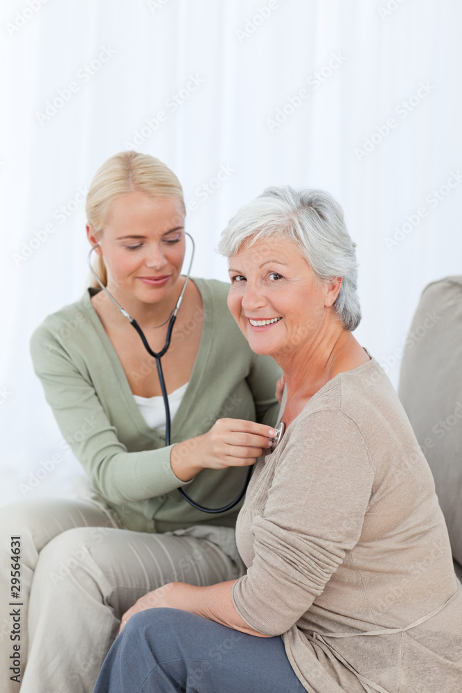 Nurse taking the heartbreat of her patient at home Nurse taking the heartbreat of her patient at home