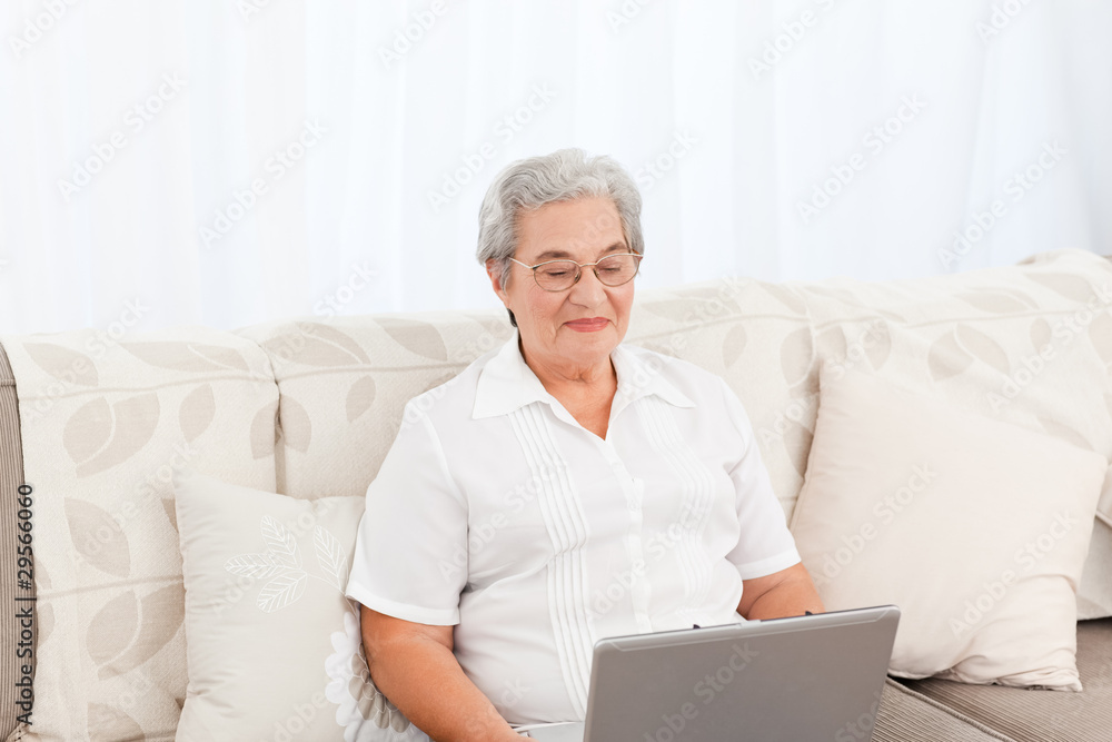 Woman looking at her laptop at home Woman looking at her laptop at home