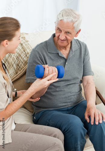 Lovely nurse helping her patient to do exercises