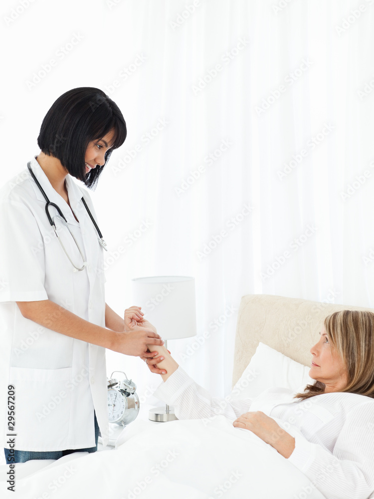 Nurse taking the pulse of her patient Nurse taking the pulse of her patient