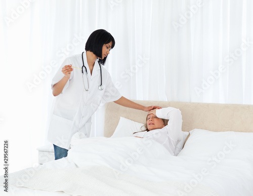 Nurse taking the temperature of her patient