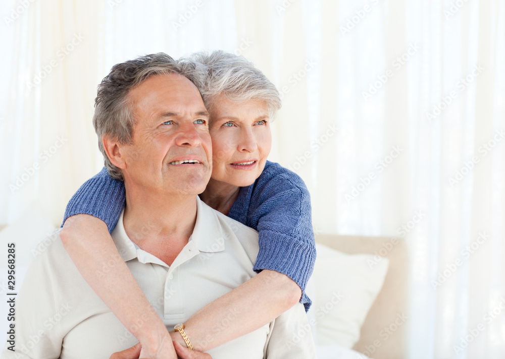 Senior couple hugging on their bed Senior couple hugging on their bed